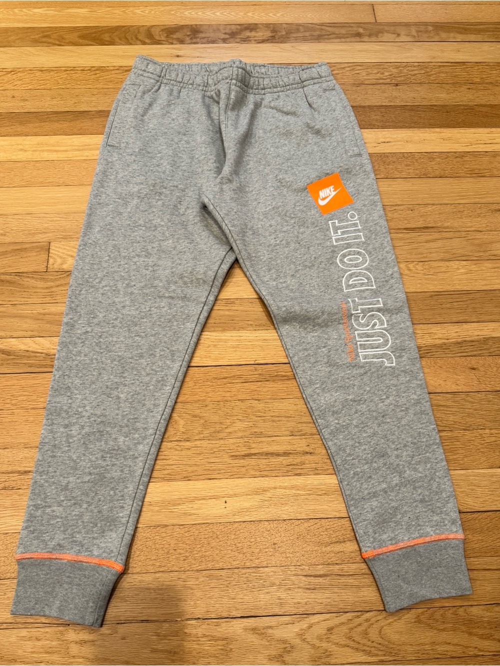 Nike Grey Joggers with Orange Accents and White 'Just Do It' Print
